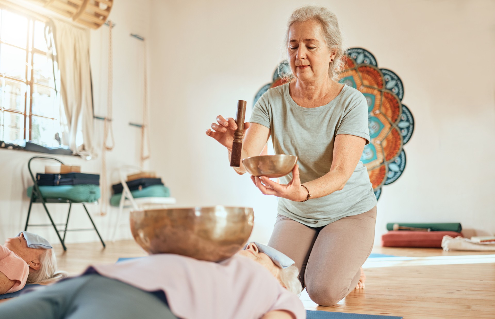 Meditation, tibetan bowl and zen senior women doing a sound healing or therapy practice in a studio. Peace, calm and elderly friends with a singing bowl for body and mind wellness, health and balance